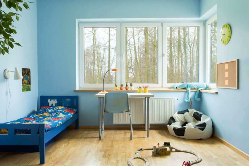 A kid’s room with a bed, desk, and soccer bean bag chair in the corner
